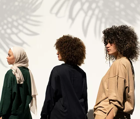 Three women in hijabs stand side by side